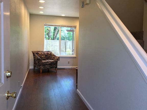 Entry hallway leading to the living room, and stairway on the right leading to three bedrooms upstairs.