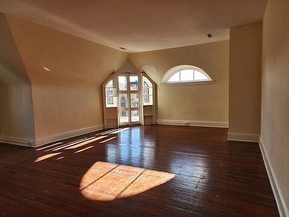 Enormous great room with door to balcony and eyebrow window.