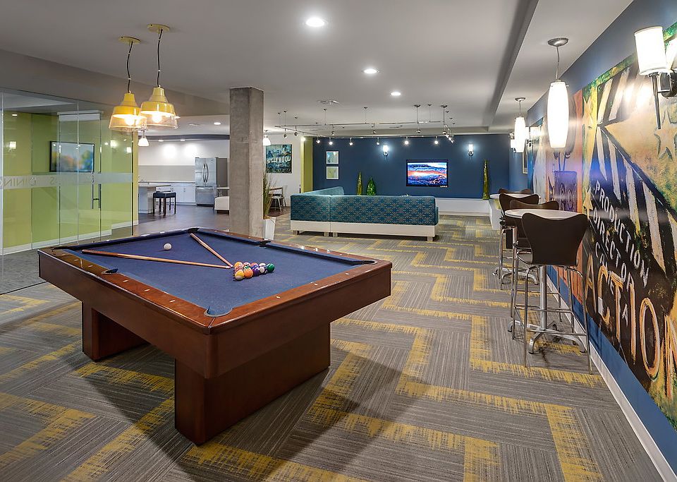 Club room with pool table, bar seating, couches, and TV.