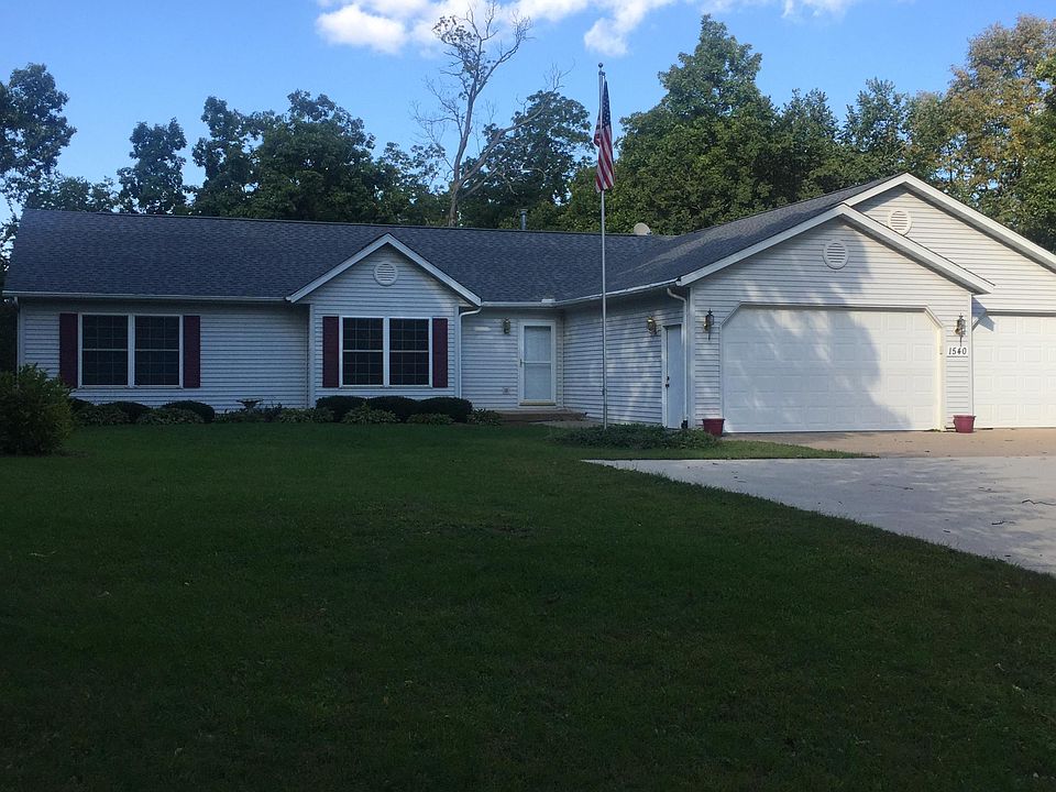 Front of the house. Paved driveway and parking area. Two-car