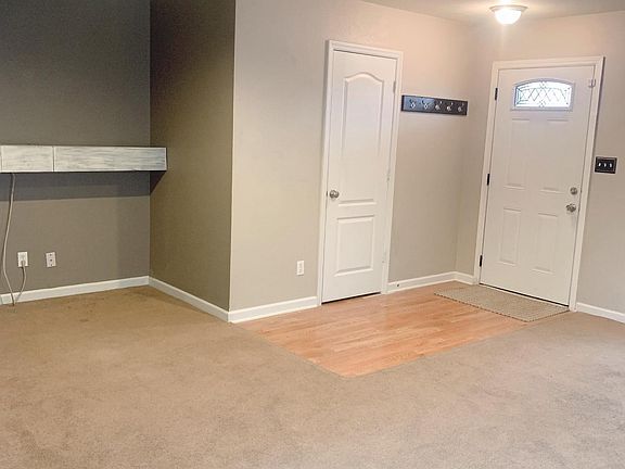 Living Room 2, showing front door and door to a half bathroom.
