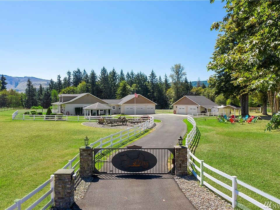 Welcome to this beautiful estate with country charm! The electric iron gate with lights provides added security and keeps your pets contained. Paved driveways, clean white fencing and antique farm equipment complete the look