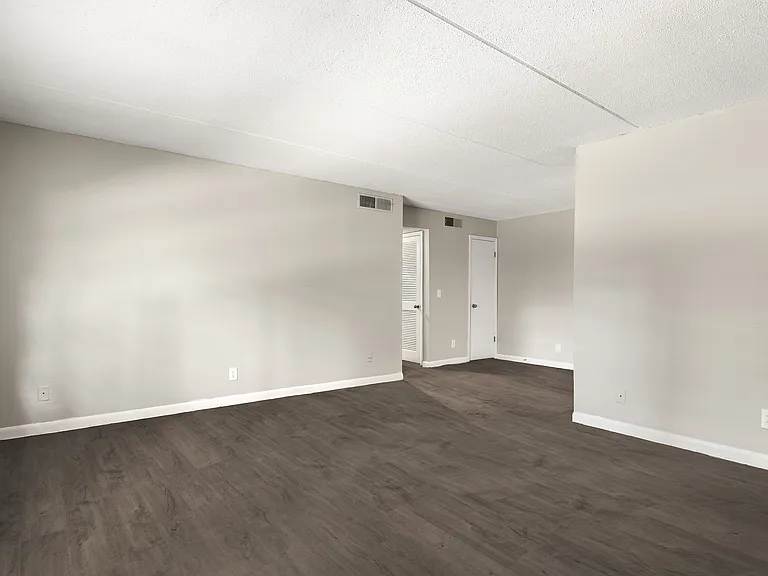 Bright and spacious room with elegant hardwood flooring and modern recessed lighting.