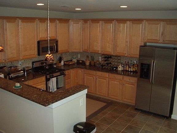 Spacious kitchen with granite, tile backsplash, and stainless steel