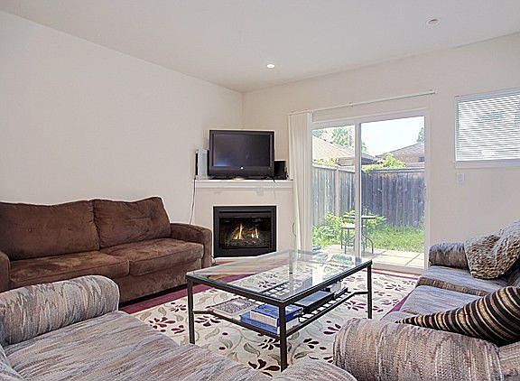 Gleaming dark wood floors with fireplace and sliders to patio.