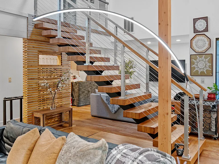 Arc lamp in living room with floating stairs in the background