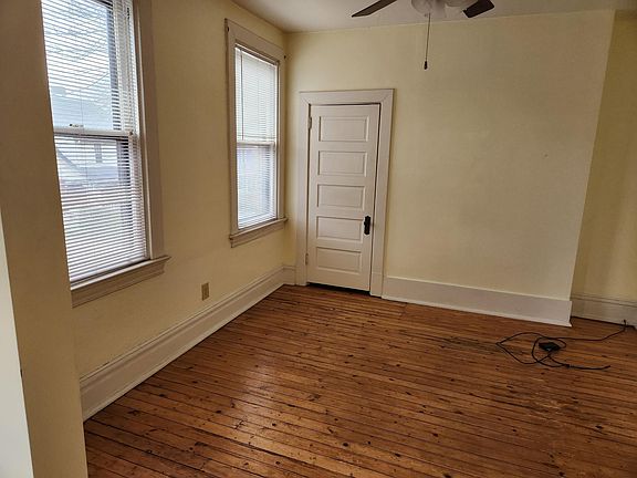 Open concept living area with closet and ceiling fan, overlooks Mifflin Ave and large shade trees outside window