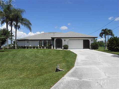 Front, towering palms, manicured lawn. Oversized garage, hurricane rated garage door, screens on garage door as well.