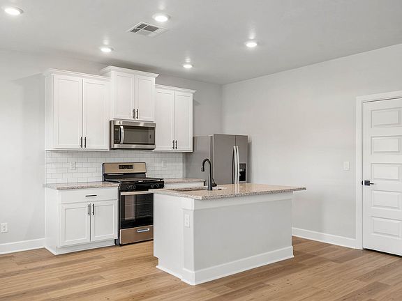 The beautiful kitchen has sprawling granite countertops.