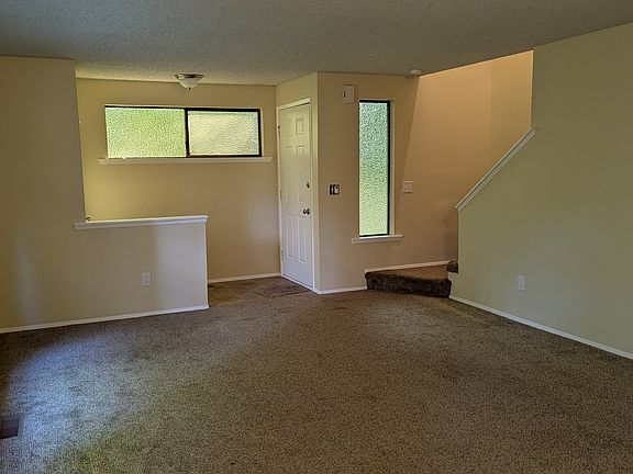 Front door; entry with coat closet; living room; stairs to second floor.