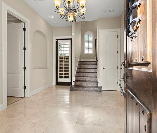 Bright foyer with travertine tile leads you to the 2 car garage, downstairs bedroom or home office, and the courtyard style patio