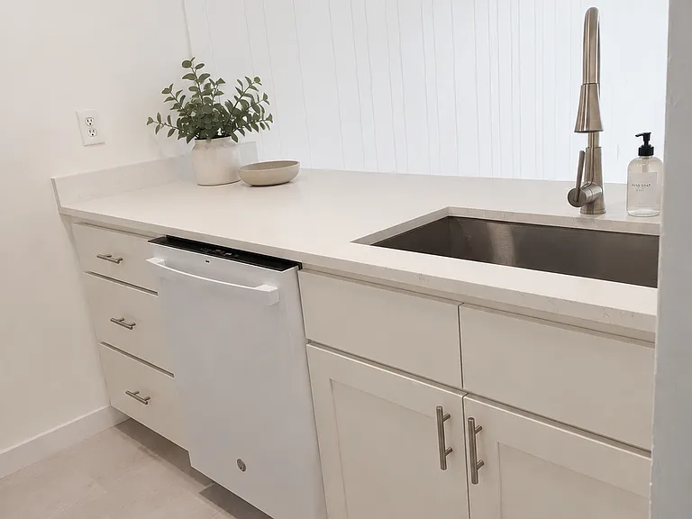Loft kitchen island with dishwasher and large sink.