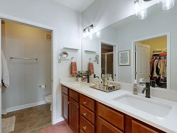 Master bath with pocket door to separate water closet/shower. Walk in closet is also off bathroom and can be seen in the mirror.