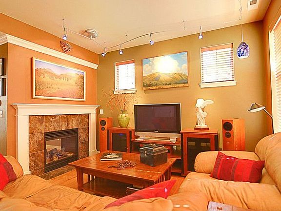 Living Room features wide-planked hardwood floors, a double-sided gas fireplace, custom lighting & surround sound system.