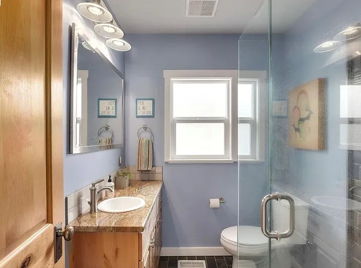 Bathroom with granite countertop and glass enclosed shower