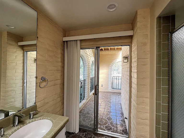 Main room bathroom with access to small interior patio.