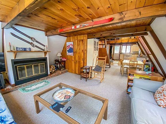 Living room with TV and wood fireplace.