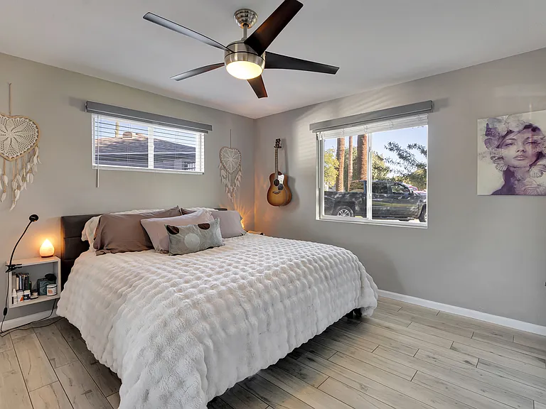 Primary bedroom with King bed, non-toxic organic mattress, and peaceful sunrise views overlooking the mesquite tree