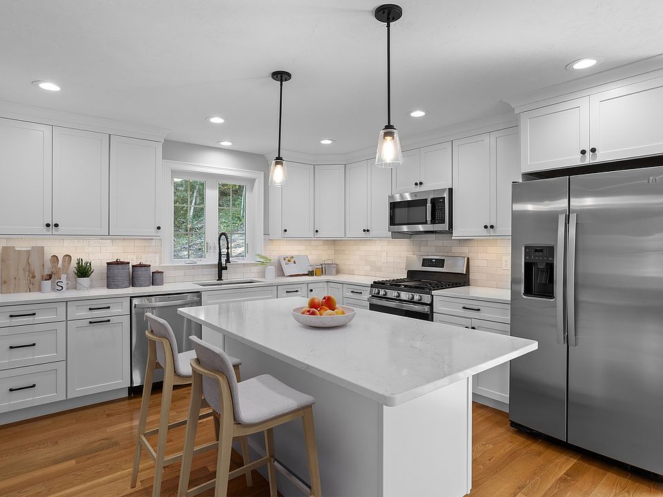 Gorgeous white Kitchen with white cabinetry, island seating for 5 and stainless steel appliances - gas stove :)