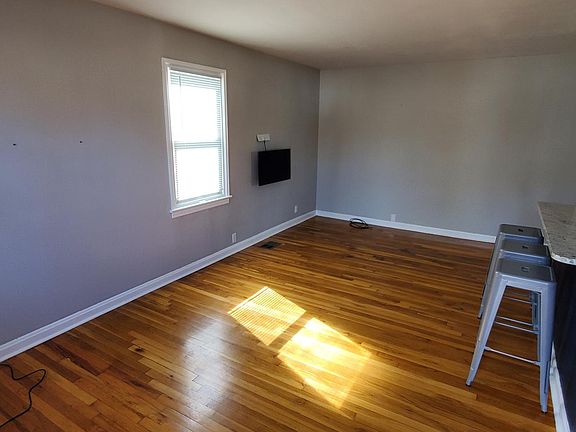 Living Room with corner light, stools at island counter, and wall mount Smart TV if tenant chooses to use them during lease