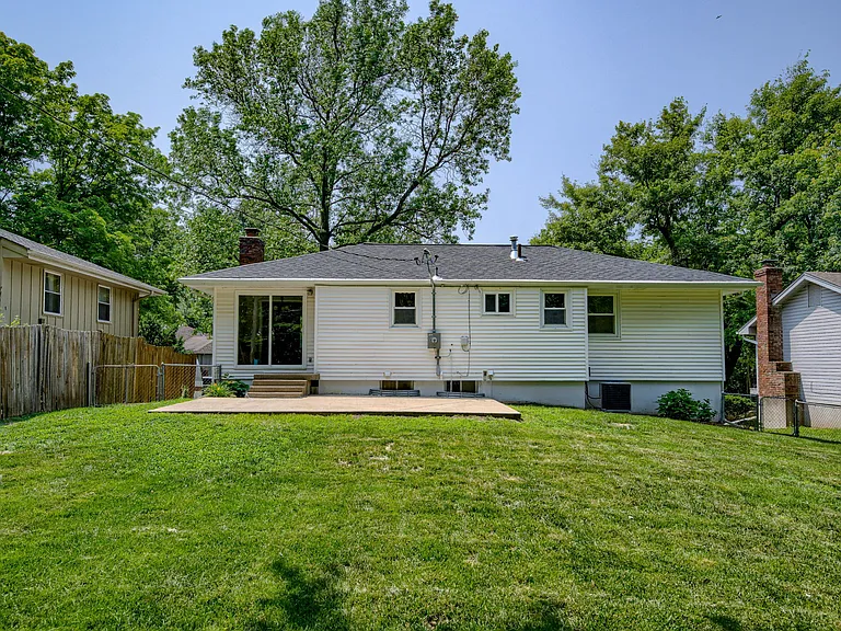 Back of home just beyond the patio looking back showing patio and rear sliding glass doors