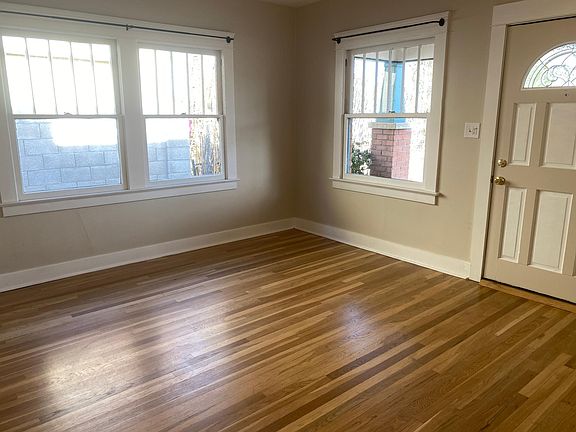 Living room and newly restored hardwood floors, ample windows.