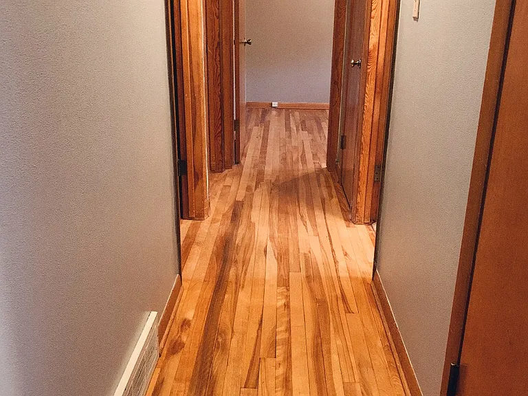 Hallway leading to bedrooms, bathroom, and coat closet (first door on right)