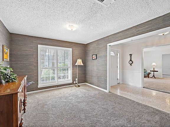 Tiled entryway and to the right is the perfect space for a home office or study area. Plantation shutters add to the character of this room.