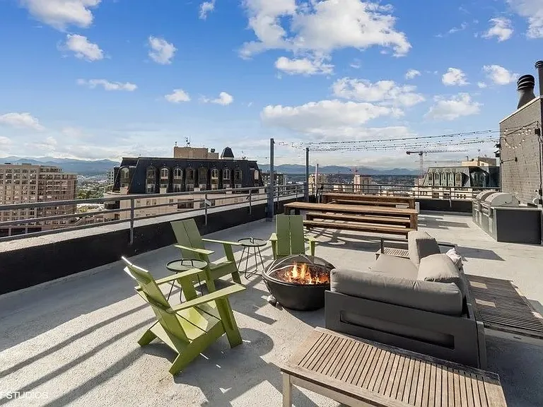 Rooftop patio with a fire pit and seating area at Archer Tower in Denver, CO