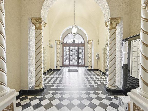 Hallway is illuminated by a chandelier hanging from the ceiling, casting a warm glow