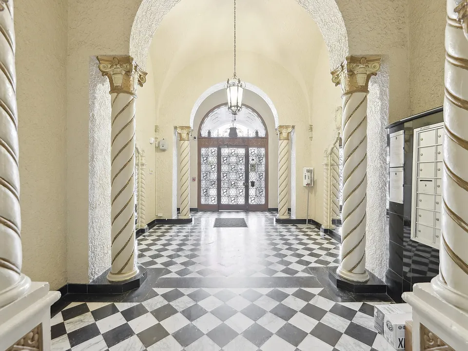 Hallway is illuminated by a chandelier hanging from the ceiling, casting a warm glow