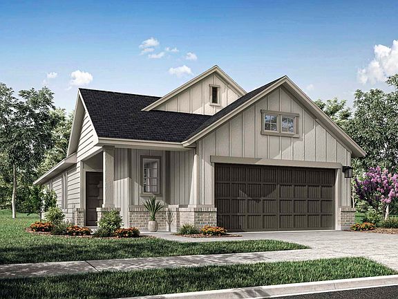 A charming two-story house with a garage, surrounded by lush greenery and a clear blue sky in the ba