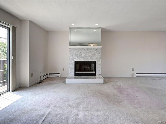 Large formal living room with raised hearth marble fireplace features sliders to deck!