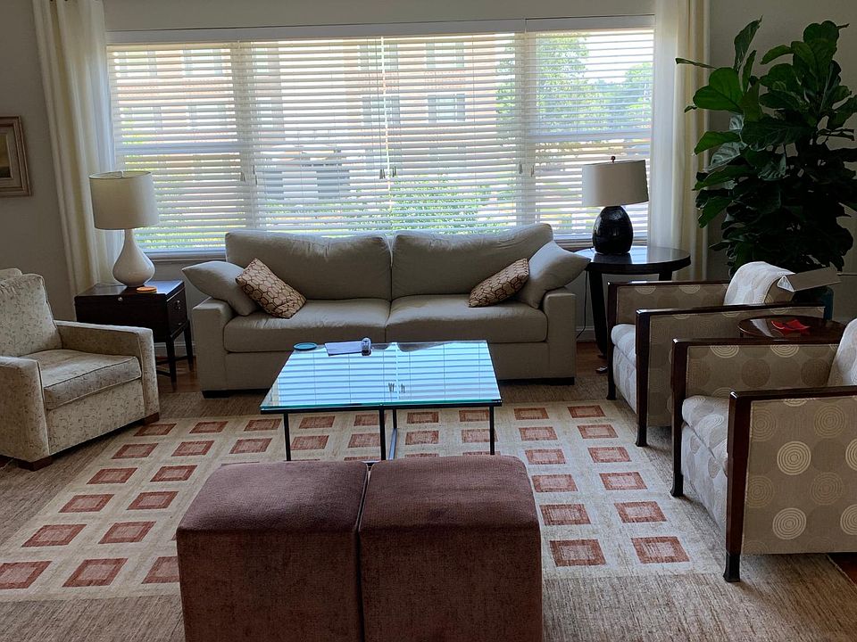 Huge living room with white wood blinds and curtain panels