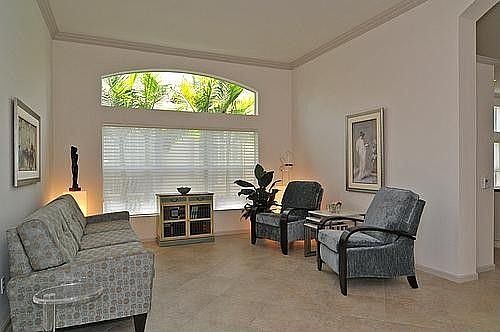 Tiled Living Room With Crown Moldings And Picturesque Arched Window