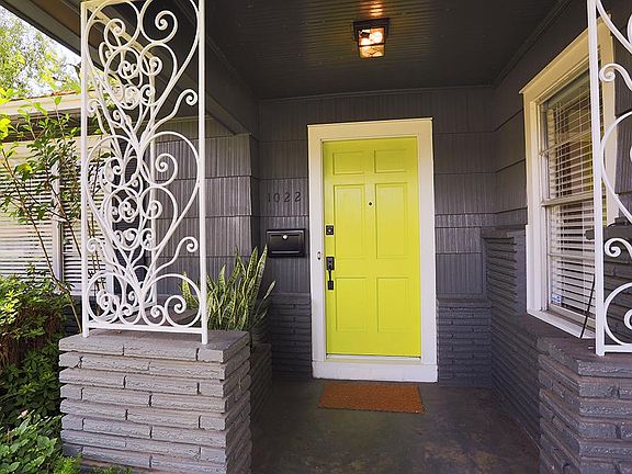 The bright door adds a great pop of color! Also note the beautiful landscaping surrounding the porch