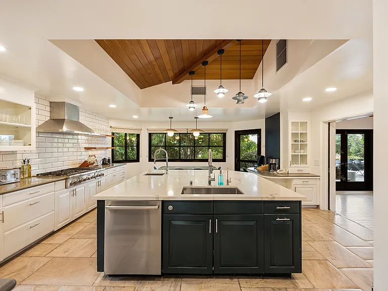Gorgeous kitchen with a blend of dark and light tones, featuring unique wood accents that bring warmth to the home.