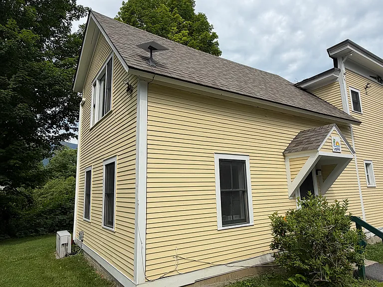 Exterior, East Side. Blackout shade installed on this window. Unit entry to the right.