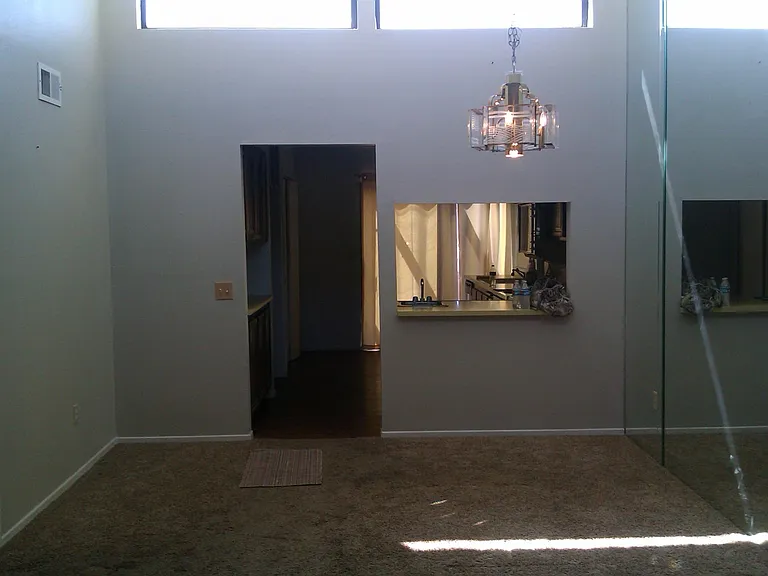 Living room of with sky lights above, photo take from the front door which has mountain views now facing and showing kitchen entrance and bar.