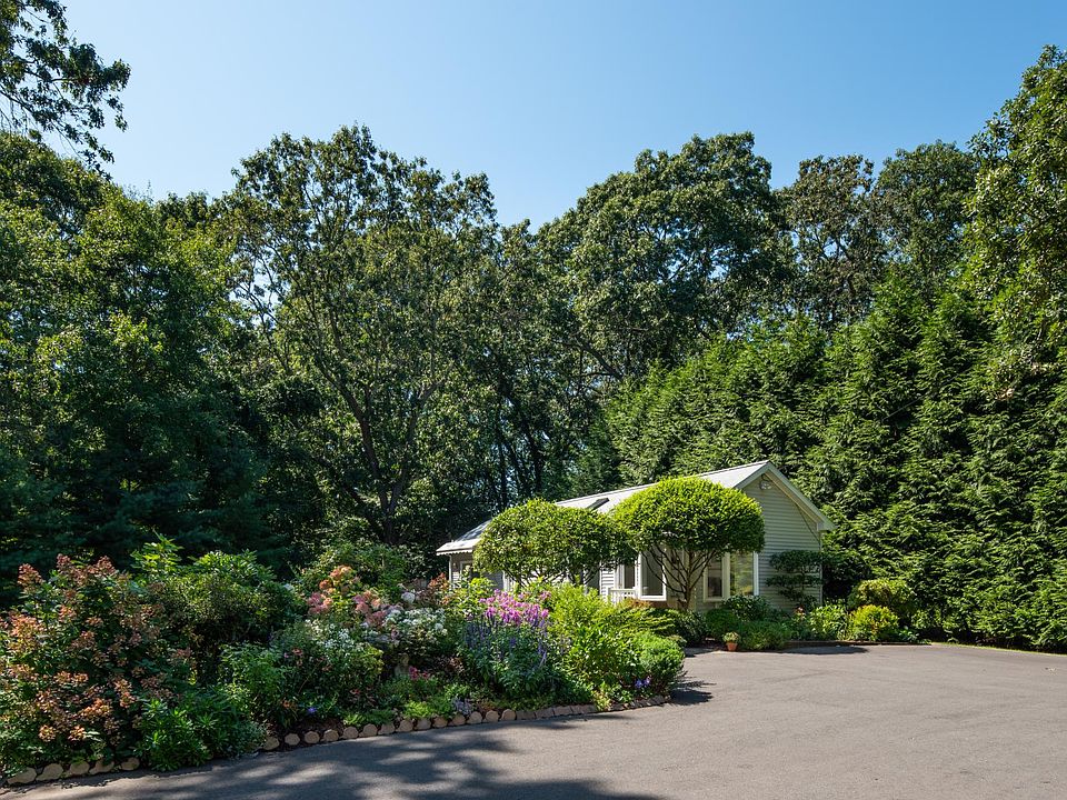 PARADISE FOUND! A must see hidden sanctuary with newly renovated private home close to the Guilford Green and I-95 Exit 58. An energy efficient free-standing ranch, framed by a water garden overlooking an expansive lawn with old growth oaks. This photo sh
