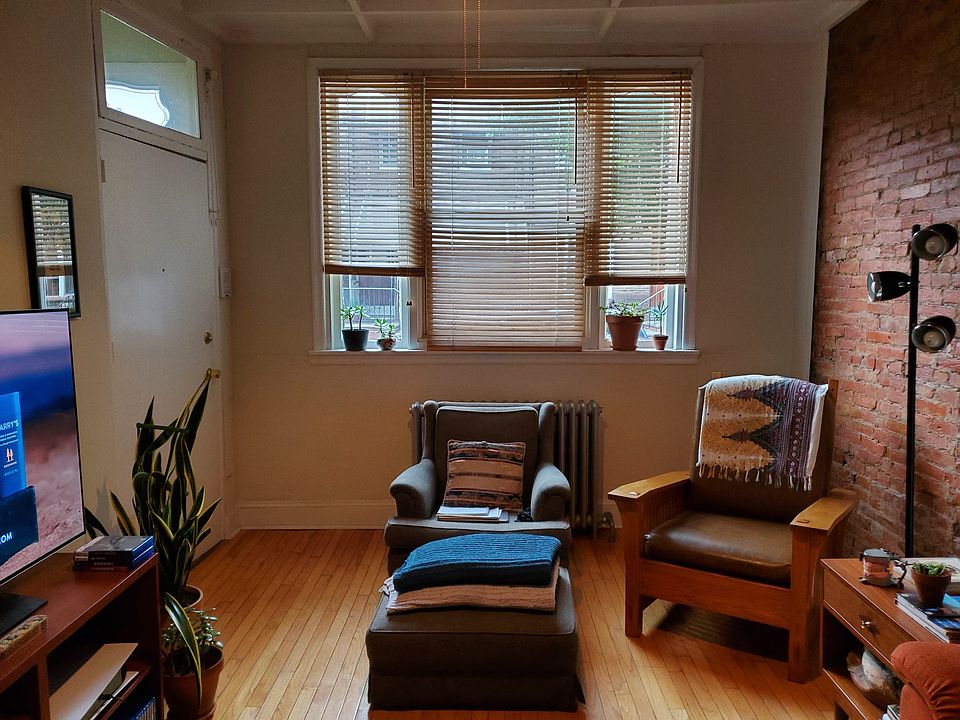 Living Room with brick wall, wood floors and beamed ceiling. It faces Dickinson Street.