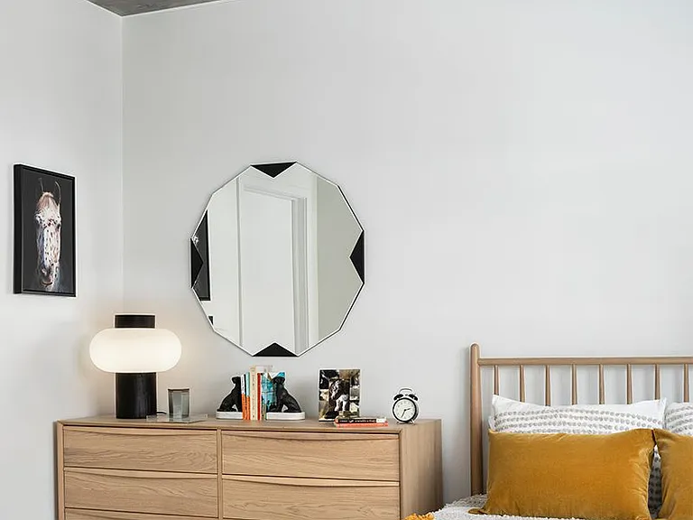 Spacious apartment bedroom with wood-style flooring.