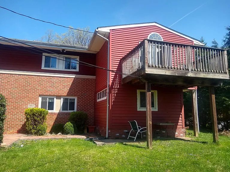 Back of house, deck off of primary bedroom
