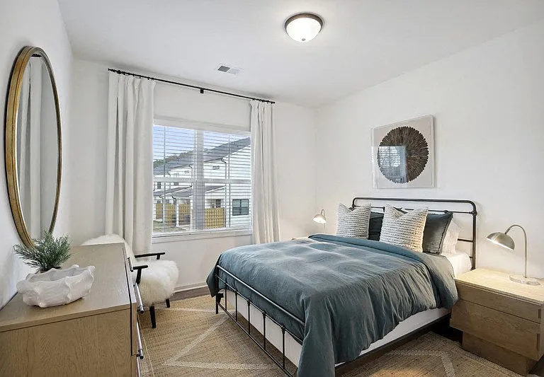 Secondary bedroom with queen size bed and large window letting in a ton of natural light.