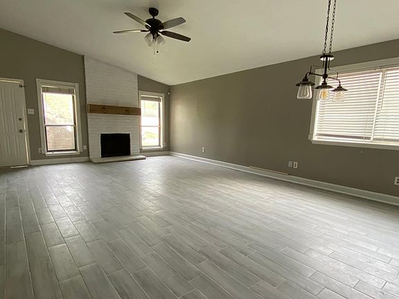 The living room with fireplace opens to the dining room with high ceilings