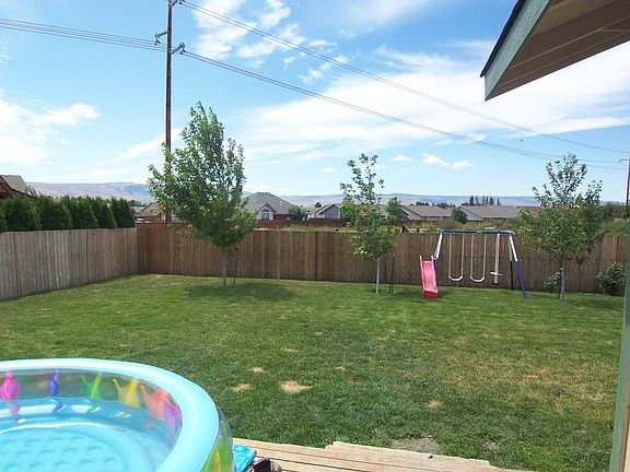 Fenced back yard with open space beyond