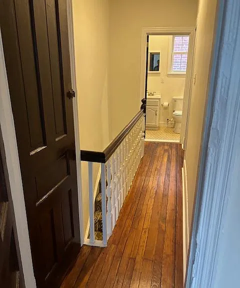 Hallway linen closet outside front bedroom, looking down hallway toward full bathroom.