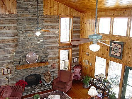 Living area with stone fireplace and lots of windows