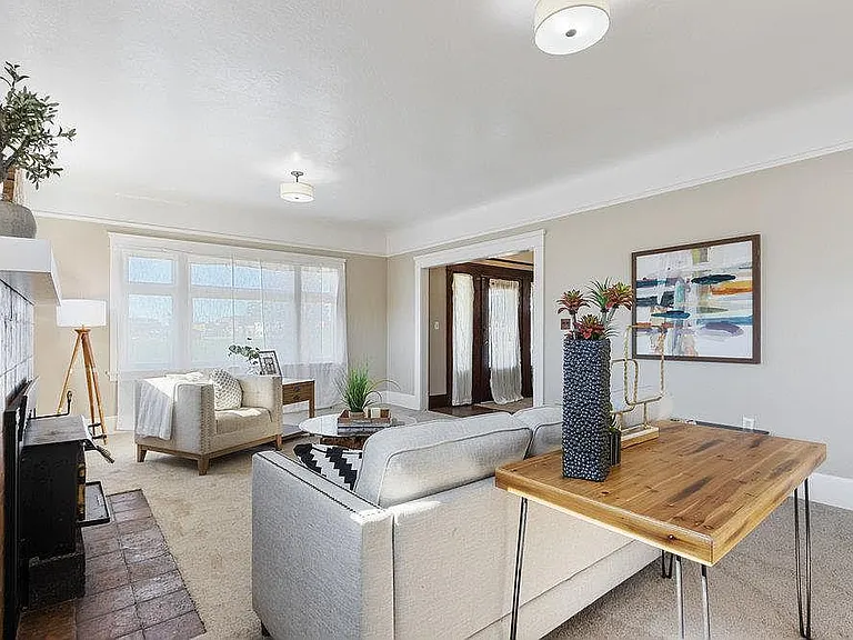 Living room- the cast iron stove is now removed and it is a simple fireplace- the floors are also hardwood throughout the carpet is gone. The walls are painted a nice creamy white not beige like the photos. There is recessed LED can lighting on dimmers th