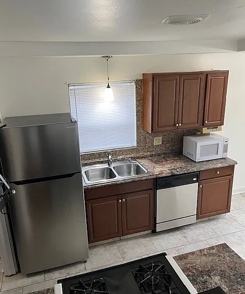 Stainless steel double sink with pull-out faucet hose.
Colorful stone backsplash/durable formica countertops.
Ample cabinets and drawers for dishware, silverware, and food storage.